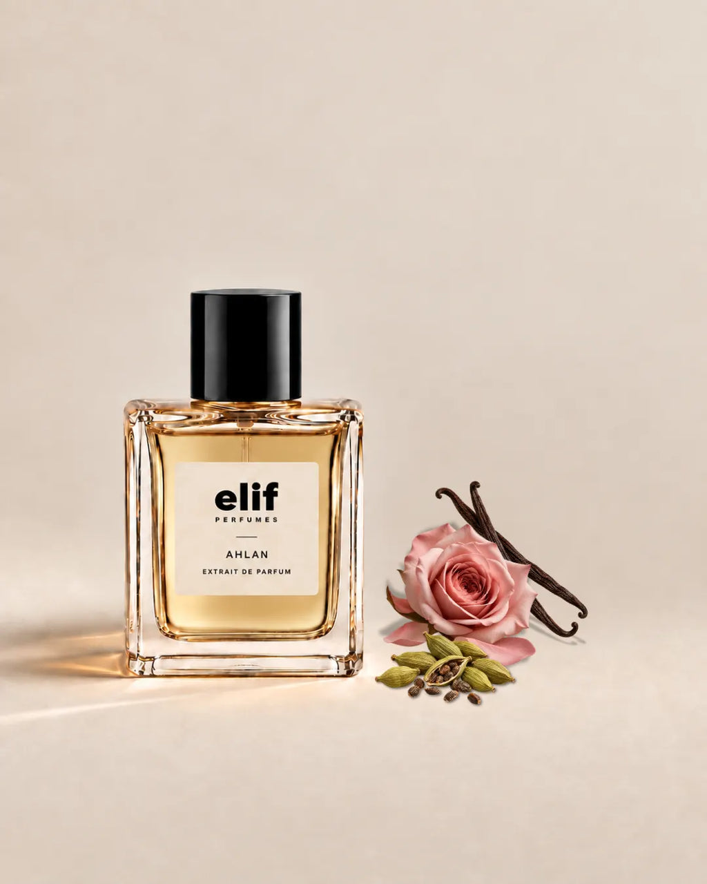 Elif Ahlan perfume bottle filled with warm golden liquid and topped with a glossy black cap, set against a soft beige background. A pink rose, vanilla pods, and green cardamom pods are arranged beside the bottle, with warm directional lighting and subtle shadows.
