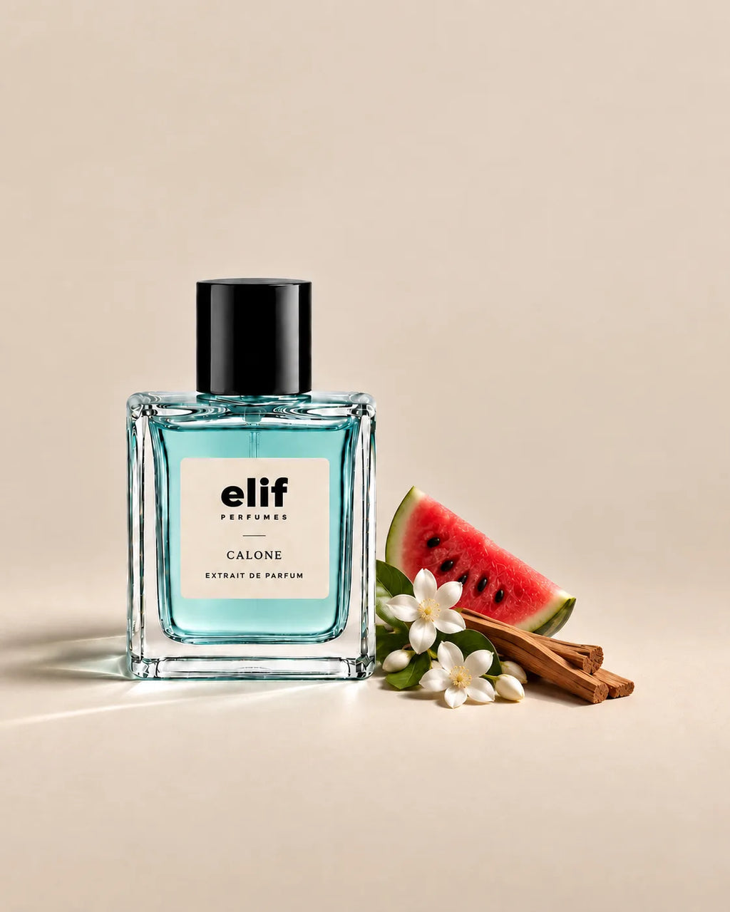 Elif Calone perfume bottle filled with translucent aqua-blue liquid and topped with a glossy black cap, displayed on a warm beige background beside a slice of watermelon, white jasmine flowers, and sandalwood sticks. A minimalist information panel identifies the fragrance as Elif Calone and lists watermelon, jasmine, and sandalwood, with descriptors 