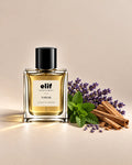 Elif Nawab perfume bottle with a warm golden liquid and glossy black cap, displayed against a soft beige background. Fresh lavender sprigs, green mint leaves, and light-colored woody pieces are arranged beside the bottle, with warm directional lighting and soft shadows. A long-lasting fragrance with a fresh, aromatic, floral, and woody character.