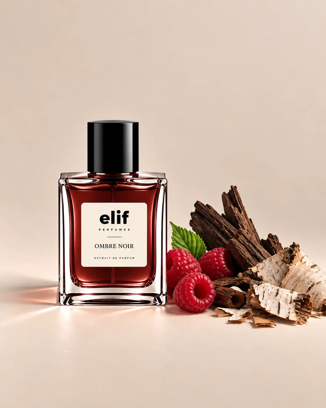 Elif Ombre Noir perfume bottle with a deep burgundy-red liquid and glossy black cap, displayed against a warm beige background. Fresh raspberries, green leaves, dark oud wood, and pale birch bark are arranged beside the bottle, with warm directional lighting and soft shadows. A long-lasting fragrance with a dark, fruity, smoky, and woody character.