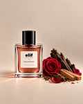 Elif Oud & Petals perfume bottle with a warm rose-toned liquid and glossy black cap, set against a soft beige background. A deep red rose, scattered rose petals, dark oud wood, and light-colored sandalwood pieces are arranged beside the bottle, with warm directional lighting and soft shadows. A long-lasting fragrance with a rich, woody, rosy, and luxurious character.