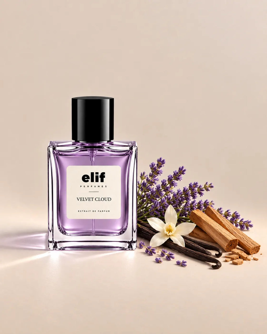 Elif Velvet Cloud perfume bottle with a soft lavender-purple liquid and glossy black cap, displayed against a warm beige background. Lavender sprigs, a white floral bloom, vanilla pods, and light-colored wood pieces are arranged beside the bottle, with soft directional lighting and subtle shadows. A long-lasting fragrance with a soft, floral, creamy, and woody character.