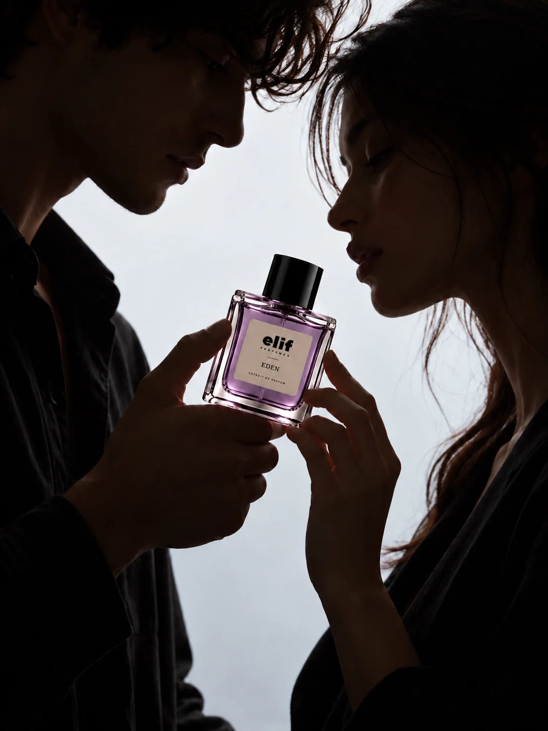 Elif Eden long-lasting perfume bottle held between a man and woman in an intimate, romantic setting, highlighting the elegant purple fragrance bottle and extrait de parfum presentation.